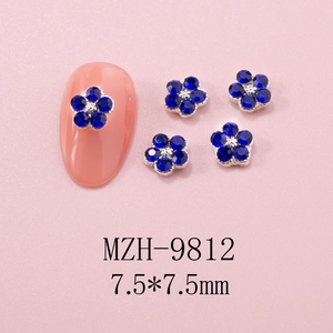 Macro shot of 7.5mm blue rhinestone five-petal flower nail art studs on pink nails