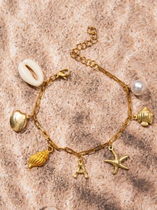 Detailed view of ocean-style gold bracelet featuring shells, starfish and initial A