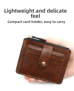 Detail of dark brown vintage leather card holder with secure snap strap and zipper pocket