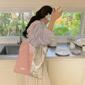 Close-up of pink velvet and silver sequin patchwork tote bag worn by a model in a kitchen
