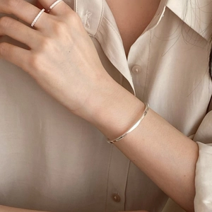 Minimalist S925 sterling silver 3mm open bangle and slim rings worn on a female wrist