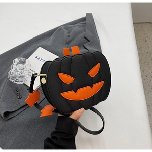 Close-up of Halloween pumpkin crossbody bag with orange face and bat strap detail