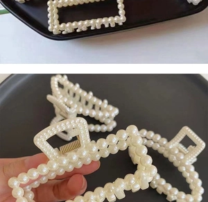 Detailed view of elegant pearl hair claw clips showing size and white pearl texture