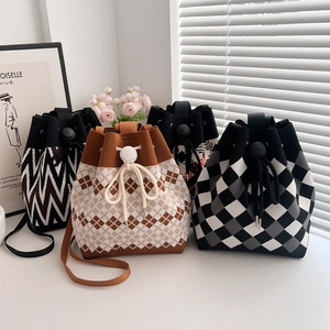 Detail view of four knitted drawstring bucket bags in various geometric patterns and colors