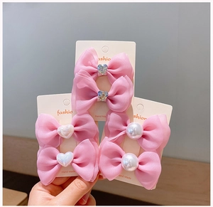 Detailed close-up of six pink tulle hair clips with pearls and crystals for girls