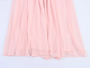 Detail of pink chiffon dress hem showing elegant pleated fabric and sheer texture