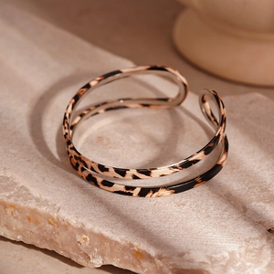 Detail of leopard print double-layered open bangle with golden edges and metal texture