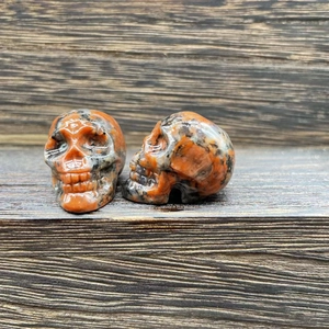 2.8cm carved natural gemstone crystal skull figurines on dark wood surface
