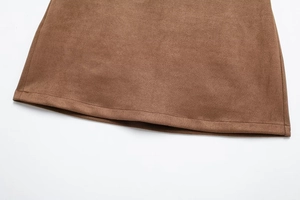 Close-up of the brown faux suede skirt hem showing detailed stitching and fabric texture