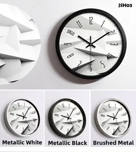 Modern wall clock detail showing 3D geometric dial in white, black and brushed silver