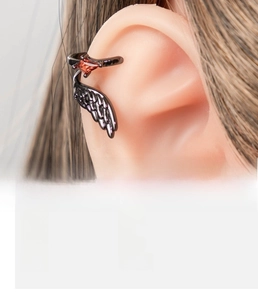 Detail of gunmetal wing ear cuff made of copper with a red diamond-shaped gemstone