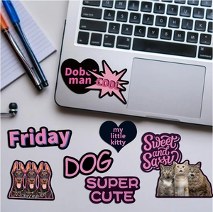 Flat lay view of black and purple graffiti stickers with Doberman and cat motifs on a desk