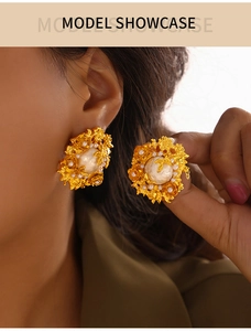 Gros plan sur les boucles d'oreilles baroques vintage avec perles et pétales dorés