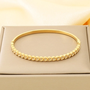 Detailed macro of gold heart bracelet with zircon pavé setting on a luxury jewelry box