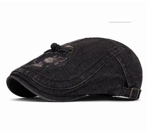 Detail der Jeans-Baskenmütze mit Vintage-Stickerei und traditionellem Knotenknopf