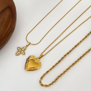 Ensemble de trois colliers superposés plaqués or 18 carats avec médaillon cœur et croix