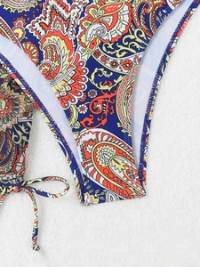 Macro view of paisley print bikini bottom with adjustable side ties on soft fabric
