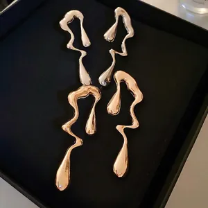 Irregular liquid metal drop earrings in silver and gold finishes with high mirror polish