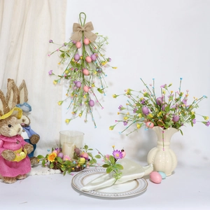 Set decorativo pasquale con uova pastello, spray floreale e corona di candele sul tavolo