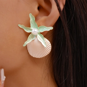Detail of beach-style starfish and shell earrings with pearls on model's ear
