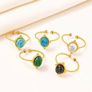 Detail of five adjustable gold rings with turquoise, marble, and malachite stone inlays