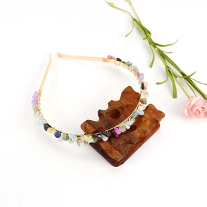 Close-up of handmade golden metal headband with colorful natural crystal stones