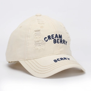 Detail of CREAM BERRY embroidery and distressed holes on off-white cotton baseball cap