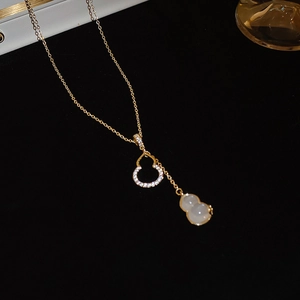 Détail du collier à double gourde dorée avec jade blanc et pierres de zircon brillantes