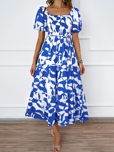 Détail de robe longue fleurie bleue avec buste smocké et jupe à volants étagés