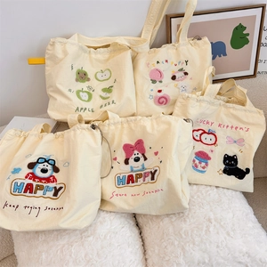 Detail of embroidered canvas tote bags with cute dog patterns and drawstring closure