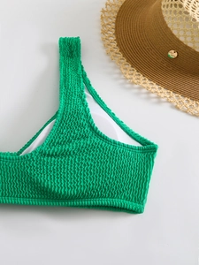 Detail of green one-shoulder bikini top with smocked texture and removable white padding