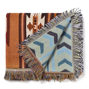 Close-up of reversible bohemian camping blanket with geometric patterns and fringe detail
