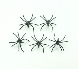 Five realistic black plastic toy spiders for Halloween decoration on white background