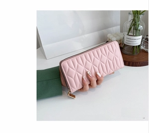 Detailed view of pink quilted PU leather wallet with golden zipper closure for women