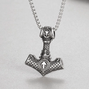 Macro shot of stainless steel Viking Mjölnir pendant with intricate totem engravings