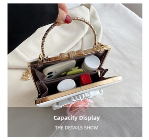 Dual compartments view of a white relief evening bag with a gold ring handle