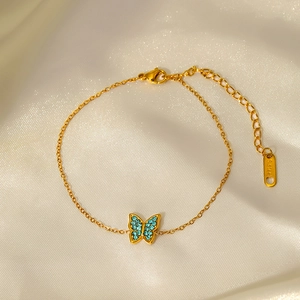 Gold stainless steel bracelet featuring a blue zircon butterfly pendant on silk fabric