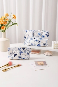 Détail de trousses à maquillage en coton et lin avec broderie florale bleue en deux tailles