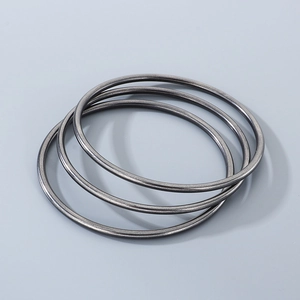 Close-up of three 3mm minimalist stackable black titanium steel bangles on grey background