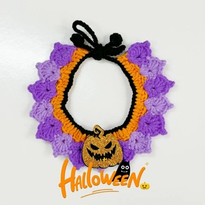 Detail of hand-knitted Halloween pet collar with purple crochet petals and pumpkin charm