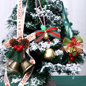 Golden Christmas bell with pine cones and red berries hanging on a snowy Christmas tree