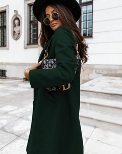 Deep green long wool coat with lapel collar and buttons in an elegant street style