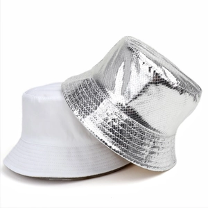 Détail d'un chapeau bob en tissu blanc et d'un chapeau argenté brillant à texture disco