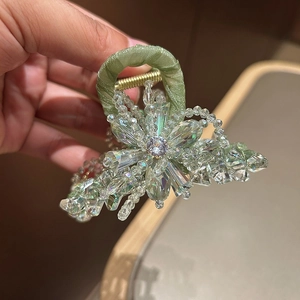 Detailed macro view of the crystal flower hair claw clip with green ribbon wrap