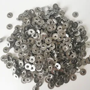Bulk metal eyelets for candle wicks piled on a white background for DIY candle making