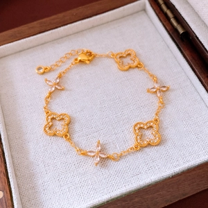 Detail view of 24K gold plated hollow floral bracelet with marquise zircon stars and clasp