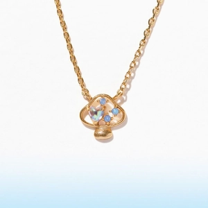 Dettaglio della collana con pendente a fungo dorato con zirconi blu e iridescenti a cuore