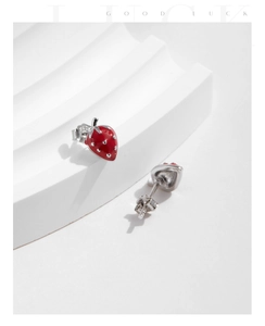 Close-up of cute red strawberry stud earrings made of S925 silver on white stand