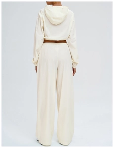 Rear view detail of cream hooded outdoor jacket and high-waisted wide-leg windbreaker pants