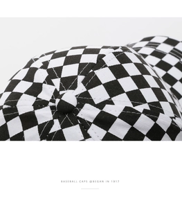Macro detail of the checkerboard baseball cap crown with stitched top button and fabric texture